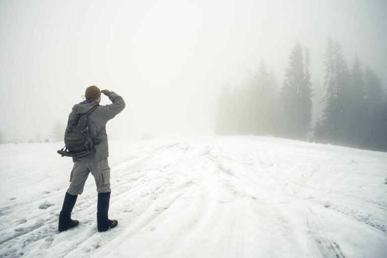 Raus aus der Arbeitslosigkeit – Diese Unterstützung gibt es 9 Man with backpack in the winter mountains peers into the foggy d