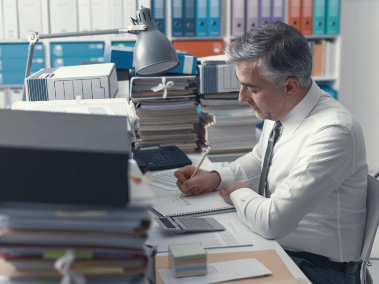 Wann verfallen eigentlich meine Überstunden? 5 businessman working in the office and piles of paperwork