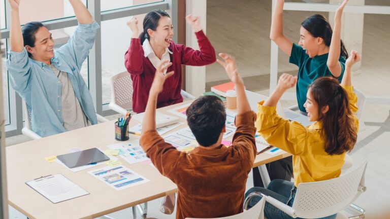 group of young creative people discussing business gesture hand high five at office