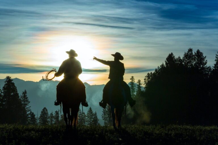Zuhause arbeiten in anderen Zeiten 2 two cowboys riding across grassland with mountains in background early morning