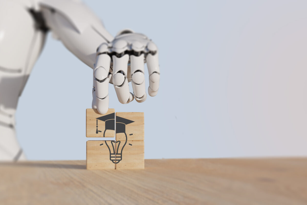 Roboterhand setzt hölzerne Puzzle-Teile zusammen, die eine Glühbirne mit Doktorhut darstellen – Symbol für künstliche Intelligenz und Bildung.
